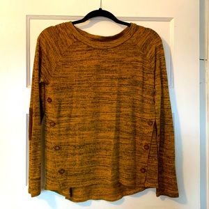 Gold sweater. Brown elbow patches and buttons.